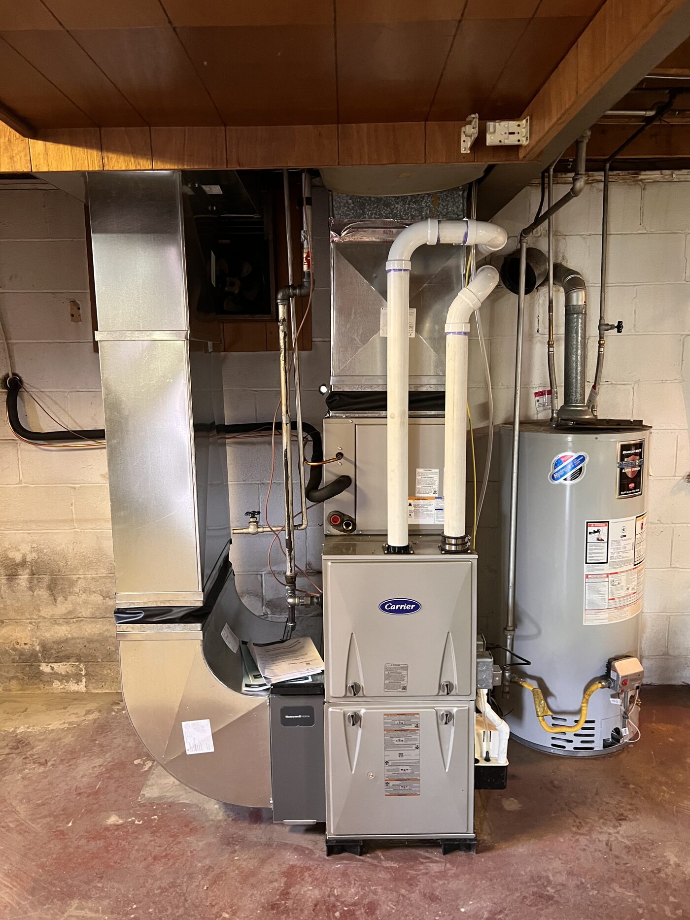 High-efficiency residential furnace install with clean PVC venting and copper line work